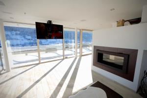 a living room with a fireplace and a flat screen tv at Villa Wie I in Kaprun