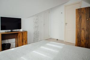 a bedroom with a bed and a tv on a wall at Cazare Conacul Tusinean in Petreştii de Jos