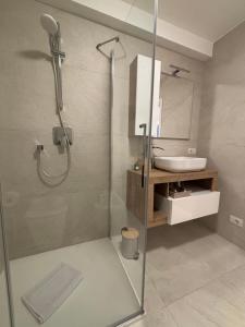 een badkamer met een glazen douche en een wastafel bij Fanzago Home in Pisogne +34 foto's