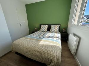 Un dormitorio con una cama con dos almohadas y una ventana. en 530 - Appartement T3, à Erquy, avec pleine vue mer, en Erquy 9 fotos más