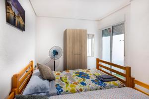 a bedroom with a bed and a fan at Cómodo apartamento cerca del metro y de la feria Valencia in Paterna