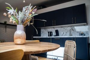 a vase of flowers sitting on a table in a kitchen at ENTRE PARENTHESE - Gîte "Enjoy" in Warlus