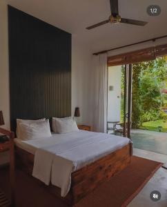 una camera da letto con un letto grande e una grande finestra di Palm Garden Ayurveda Resort ad Ahangama Altre 67 foto