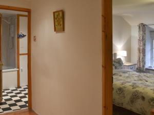 ein Schlafzimmer mit einem Bett und einem Schachbrettboden in der Unterkunft Blackberry Cottage in Kenton + 13 Fotos