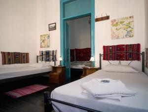a room with two beds and a mirror at Pension Nora in Chania