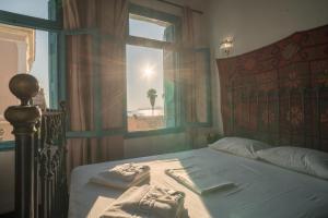 a bedroom with a bed with a window and towels at Pension Nora in Chania