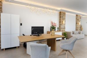 a living room with a desk with a television and chairs at Axopetra Boutique Hotel in Agiassos