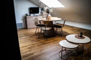 a room with two tables and chairs and a television at ENTRE PARENTHESE - Gîte "Enjoy" in Warlus