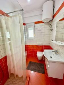 a bathroom with a toilet and a sink at Electra The Seaside Apartments in Sarandë