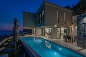 une villa avec piscine la nuit dans l'établissement Villa Mariva, à Mlini