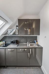 a kitchen with a sink and a counter top at Jesmond 2BR Apartment with Parking & WiFi in Jesmond