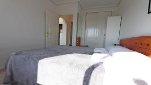 a bedroom with a large white bed in a room at R-2428 APARTAMENTO CORINTO in La Mata