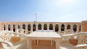 a white table and chairs in a room with vases at R-2428 APARTAMENTO CORINTO in La Mata