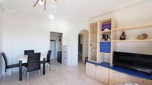 a kitchen and dining room with a table and a television at R-2428 APARTAMENTO CORINTO in La Mata