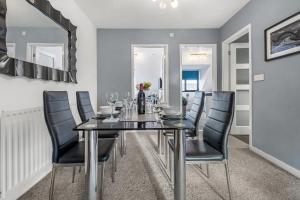 a dining room with a black table and black chairs at Jesmond 2BR Apartment with Parking & WiFi in Jesmond