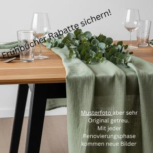 a table with green table runners and wine glasses at FeWo - EG Apartment Mosel- & Weinquartier, Terrasse, Parkplatz, moderne Küche bis 4 Personen in Piesport