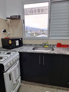 una cucina con fornelli, lavello e finestra di Santa Rita Dpto 9 a San Fernando del Valle de Catamarca