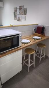 a kitchen with a counter with a microwave and two stools at #BelEstere - Netflix - Clim - Parking in Eauze