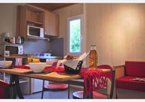 a kitchen with a table with two chairs and a dining room at Camping La Chapelle in La Chapelle-Taillefert