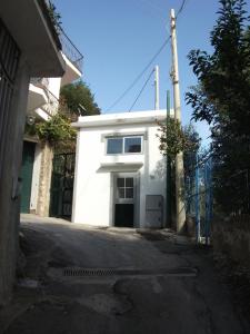 biały budynek z drzwiami na ulicy w obiekcie Ruderi w mieście Cetara
