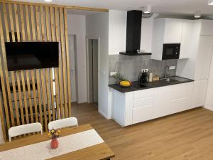 a kitchen with white cabinets and a table and a counter at Apartma Tomy in Domžale