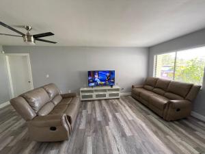 a living room with two couches and a flat screen tv at House in Port St Lucie in Port Saint Lucie