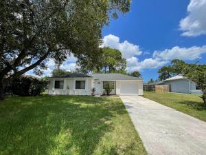 a white house with a tree and a driveway at House in Port St Lucie in Port Saint Lucie