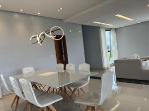a dining room with a table and white chairs at Casa COP 30 alto padrão in Santa Isabel do Pará