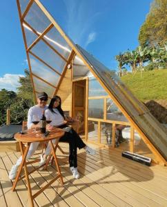 ManzanilloGlamping Aire Sevilla Valle的一男一女坐在小房子的露台上