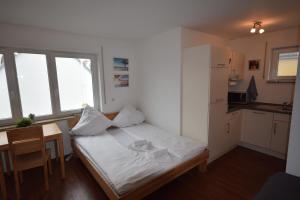 a bedroom with a bed and a table and a kitchen at Nestwerk Clever R23-24 - Work and Relax in Biberach an der Riß