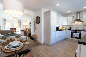 Una cocina y una sala con una mesa y un comedor. en SeaBreeze Portstewart, en Portstewart