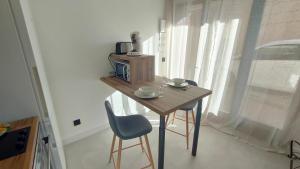 a small table with two chairs and a microwave at L'Escale Zen # Parking - WIFI Fibre - Au Calme in Challes-les-Eaux