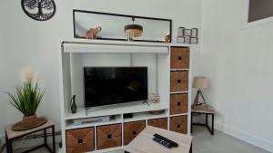 a living room with a flat screen tv on a shelf at L'Escale Zen # Parking - WIFI Fibre - Au Calme in Challes-les-Eaux