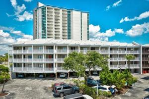a large building with cars parked in a parking lot at Seasons In The Sun in North Myrtle Beach