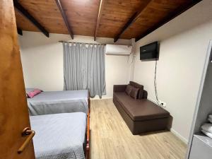 a small room with two beds and a couch at Duplex Tucumán in Colón
