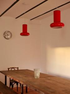 ein Esstisch mit roten Lichtern und einer Uhr in der Unterkunft Ferme des Millonets - grand gîte in Vienne-en-Arthies