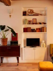 ein Wohnzimmer mit einem TV auf einem weißen Regal in der Unterkunft Ferme des Millonets - grand gîte in Vienne-en-Arthies