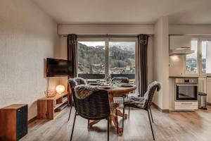 Una cocina y un comedor con mesa y sillas. en Apartment with balconies at the foot of the slopes, en Les Houches