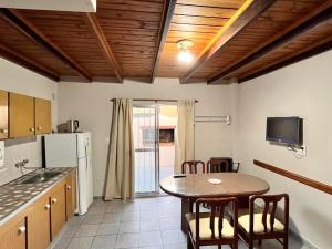a kitchen with a table and a table and chairs at Duplex Tucumán in Colón