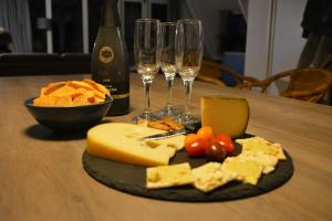 a plate of cheese and wine glasses on a table at Villa Pimpelmees - Sunclass 54 in Durbuy