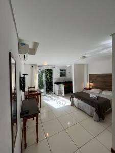 a bedroom with a bed and a desk in it at Casa Figueira na Pedra - SPA Suites in Florianópolis