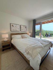 a bedroom with a large bed and a large window at Chalet L'Estuaire, River View, Spa in Saint-Joseph-de-la-Rive +57 photos