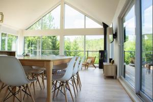 a dining room with a table and chairs at Chalet L'Estuaire, River View, Spa in Saint-Joseph-de-la-Rive