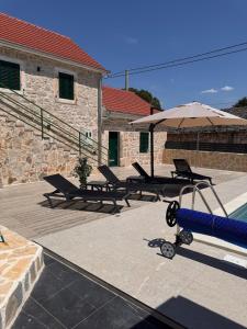 a table and an umbrella next to a pool at Villa Zvonimir in Suknovci