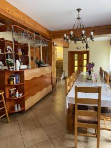 a dining room with a long table and chairs at PENSIUNEA SIMONA ARIESENI in Arieşeni +22 photos