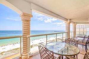 - un balcon avec une table et des chaises et la plage dans l'établissement Beach Club Gulf Front 4B Condo - 1106, à Pensacola Beach