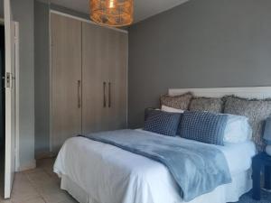 a bedroom with a bed with a blue blanket on it at Pips Place 203 in Strand
