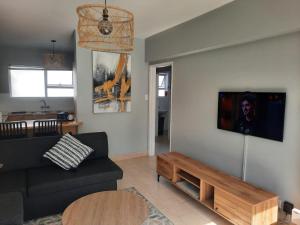a living room with a black couch and a table at Pips Place 203 in Strand