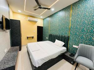 a bedroom with a bed and a chair in a room at Hotel Airport Fly Inn in Lucknow