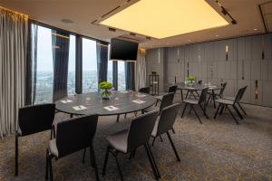 伦敦art'otel London Hoxton, powered by Radisson Hotels的一间有桌椅和大窗户的会议室 更多37张照片